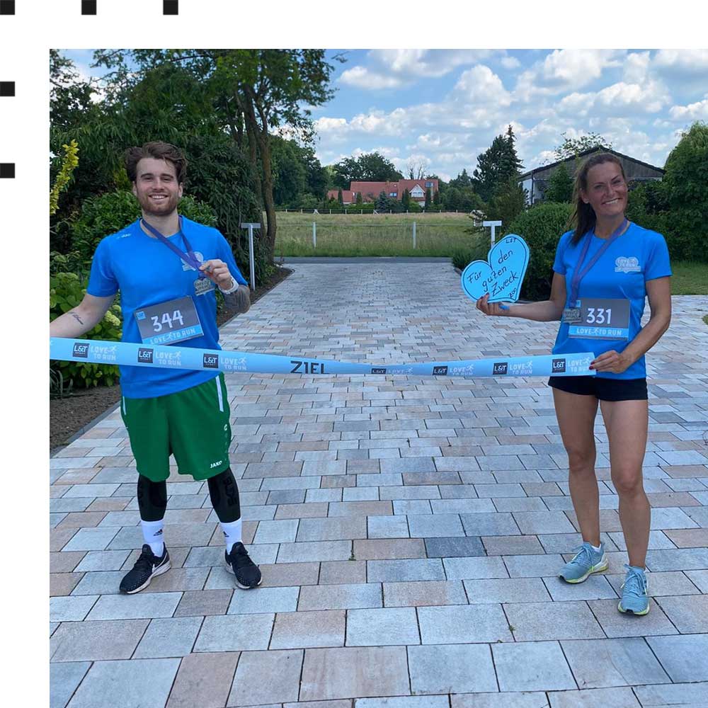 Ein Mann und eine Frau halten ein Band mit der Aufschrift "Ziel" beim L&T Lauf in Osnabrück.
